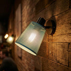A cone-shaped metal shade in blue paired with a matte black wall mount and arm.
