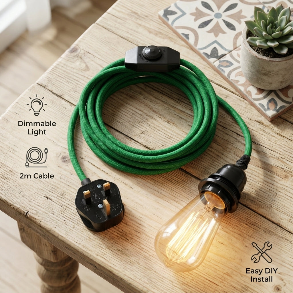 A green fabric-covered extension cord with a black switch, UK three-pin plug, and glowing warm-white Edison bulb, displayed on a wooden table. Text callouts mention 'Dimmable Light', '2m Cable', and 'Easy DIY Install'.