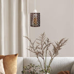 A lit metal cage lamp shade hanging in a living room.