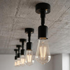 A set of modern industrial pendant lights with matte black metal fixtures 