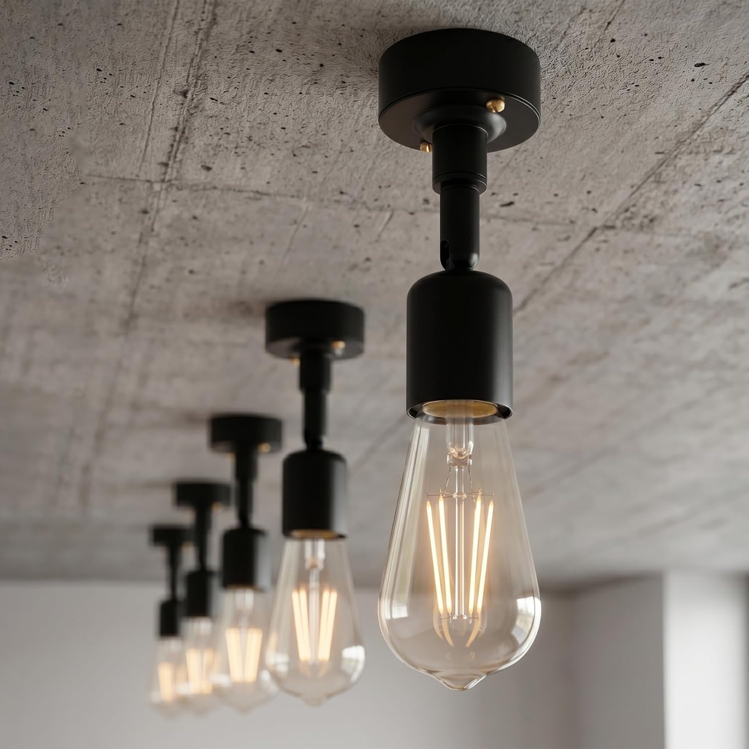 A set of modern industrial pendant lights with matte black metal fixtures 