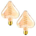 Heart-shaped E27 LED filament bulb, amber glass, lit, two bulbs on a white background