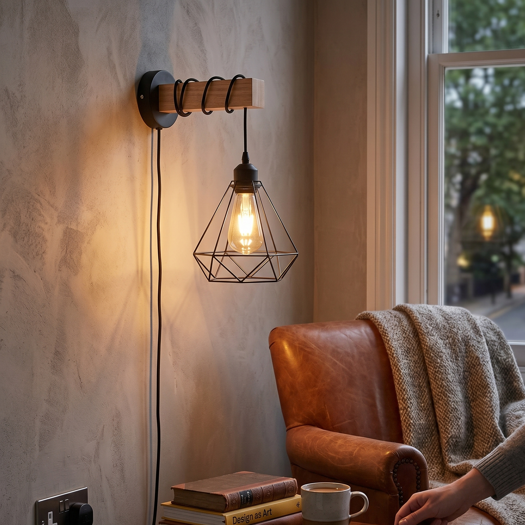 Cozy room with a leather armchair, wall-mounted lamp, and books on a small table.
