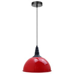 A modern pendant light with a glossy red dome-shaped shade and a matte black ceiling canopy, cord, and connector, shown against a plain white background.