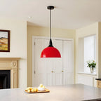 A red pendant light hangs above a kitchen island in a room with a fireplace and a painting.