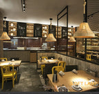 Three lit vintage hemp rope pendant lights hanging in a restaurant setting.